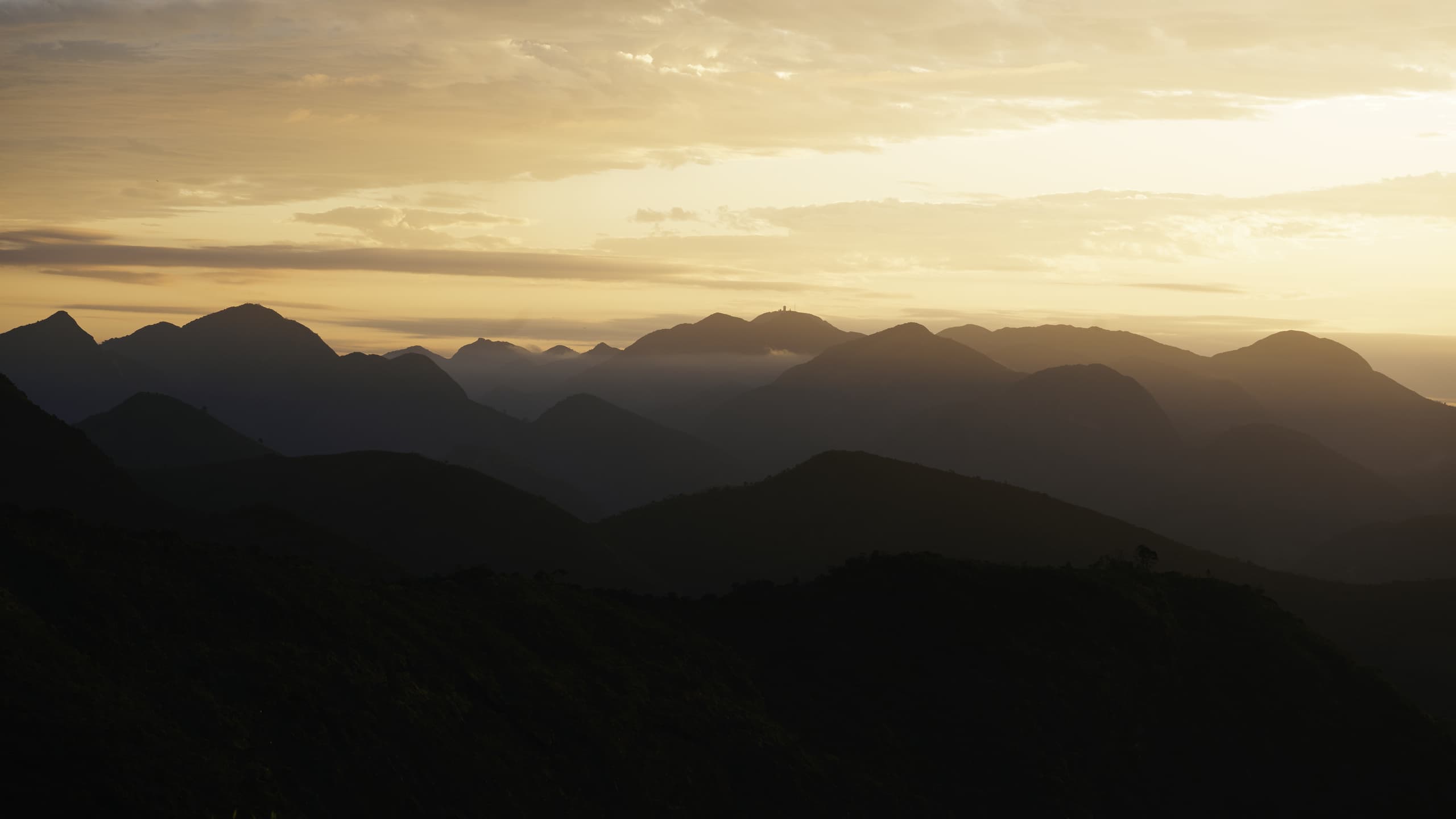 Landscape shot of a sunset with several layers of mountains